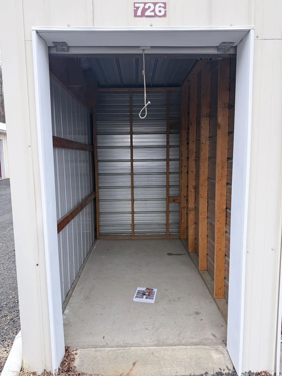 Interior of a 5x10 residential storage unit in Scranton with wooden shelving frame and horizontal metal storage slats, concrete floor, and clear space for personal items